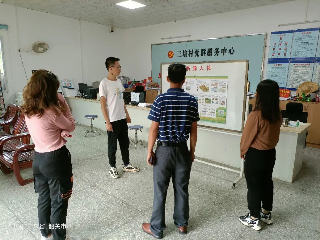 韶关翁源县坝仔镇三坑村村委工作人员向村民讲解“广东省村庄规划实用指南”宣传海报内容.jpg