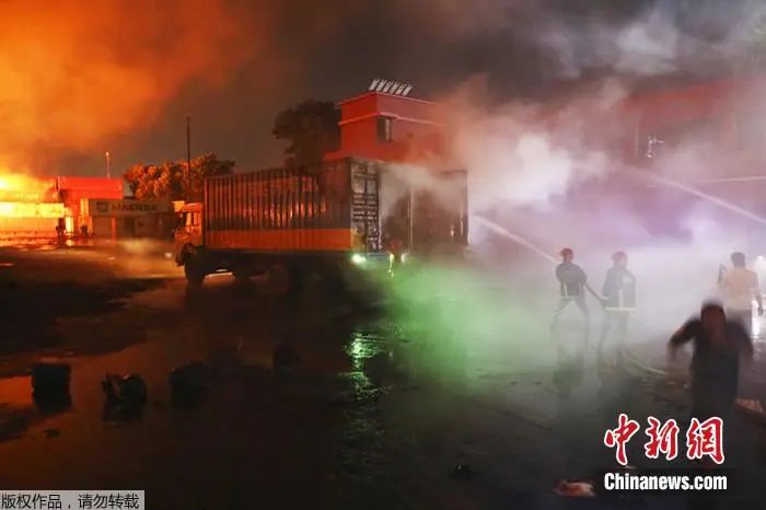 当地时间5日,孟加拉南部地区,消防队员正在努力控制集装箱仓库发生的火灾。