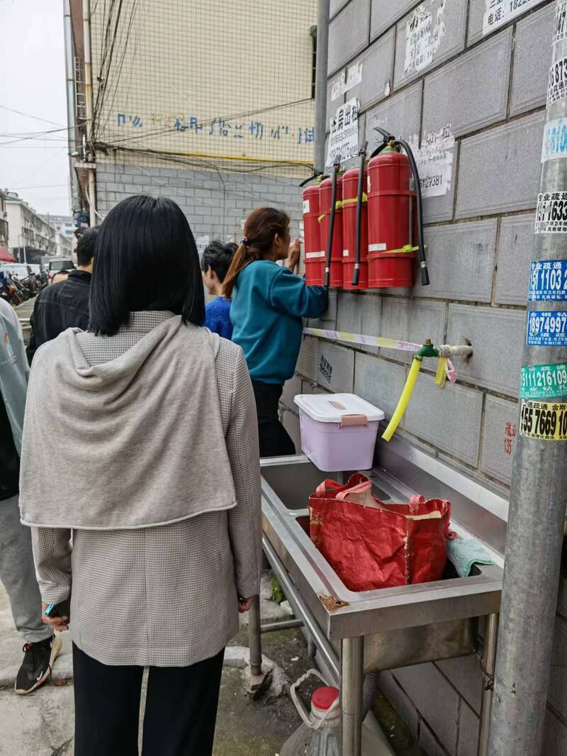 图为商业街内商铺老板设法将店内物资带出。中青报·中青网记者 洪克非/摄